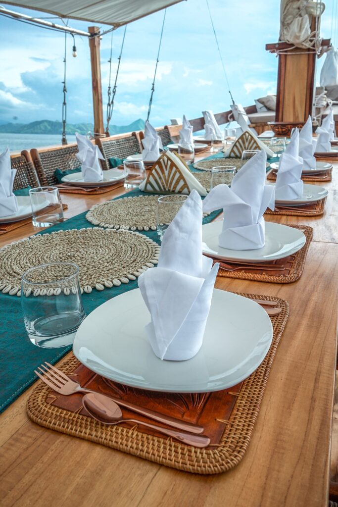Table setting with woven placemats, folded napkins, and rose gold cutlery