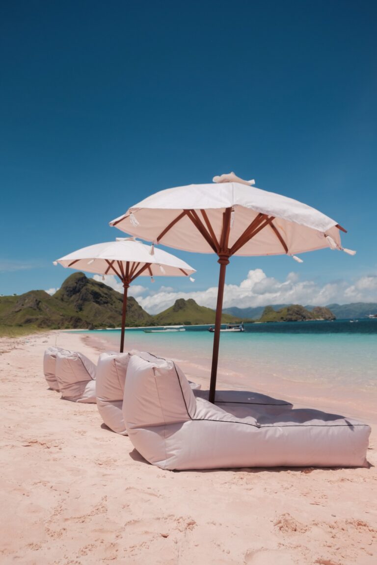 Vinca Voyage Komodo liveaboard beach stop with pink sand and white umbrellas