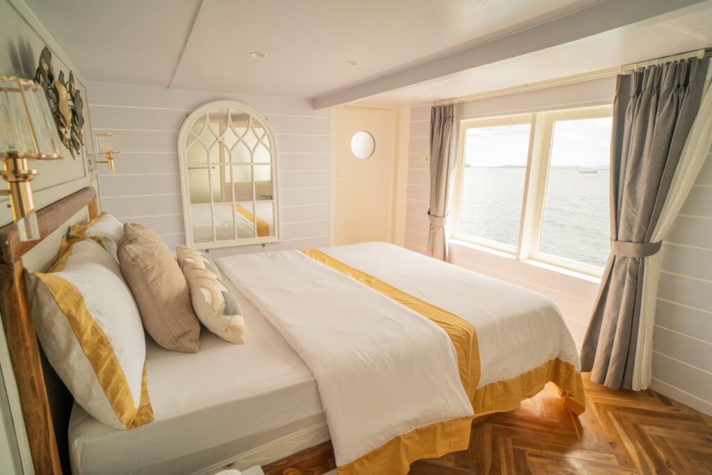 Zada Nara's Master Suite with a queen bed and large windows framing open sea