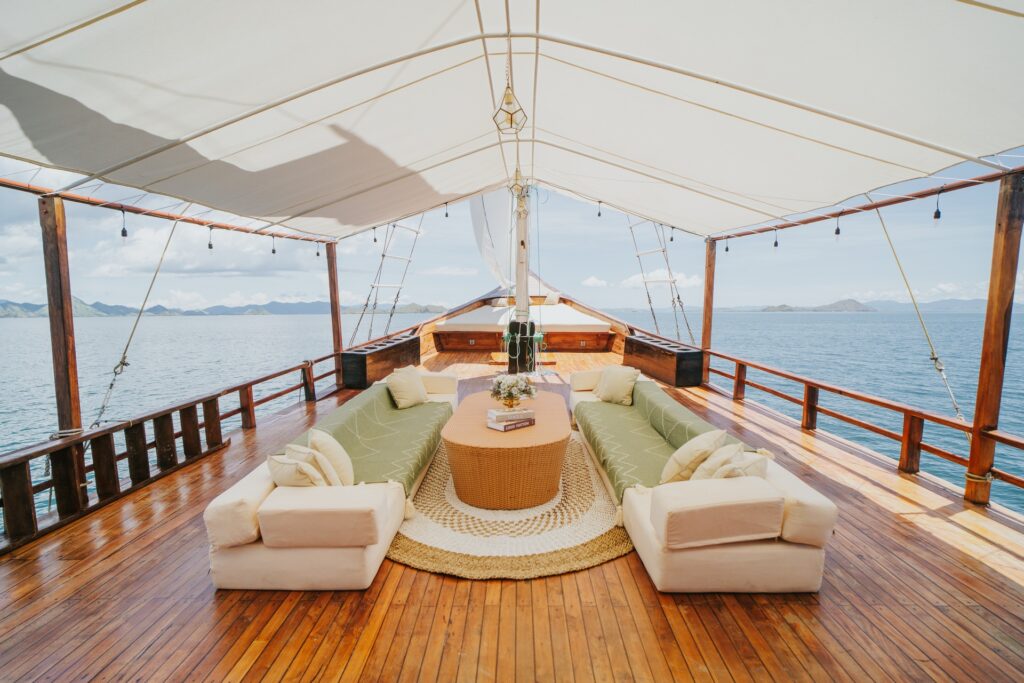 Shaded main deck with symmetrical sofa seating and a walkway leading toward the bow