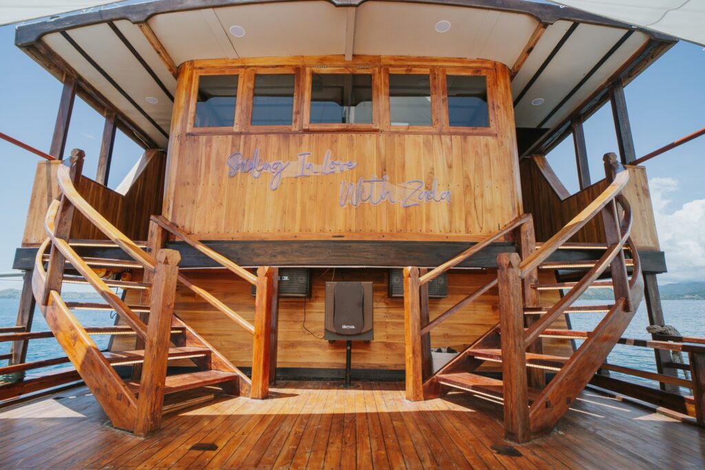 Twin curved wooden staircases lead to Zada Nara's upper deck past a carved sign
