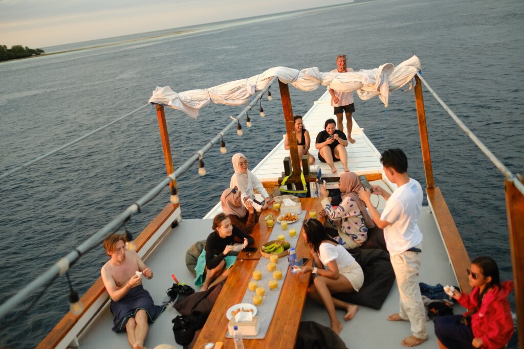 Guests gathered on Zendaya's bow deck at dusk under string lights and white canopy drapes