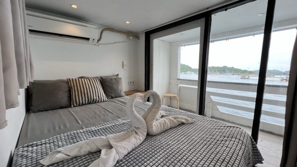 Zendaya cabin bed with a swan towel display facing sliding glass doors to the deck