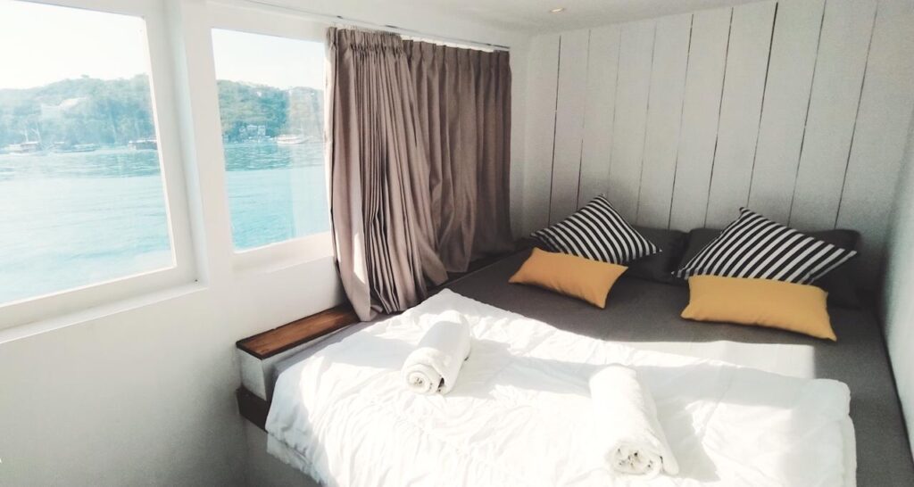 Zendaya main deck cabin with mustard pillows and large windows overlooking the harbor