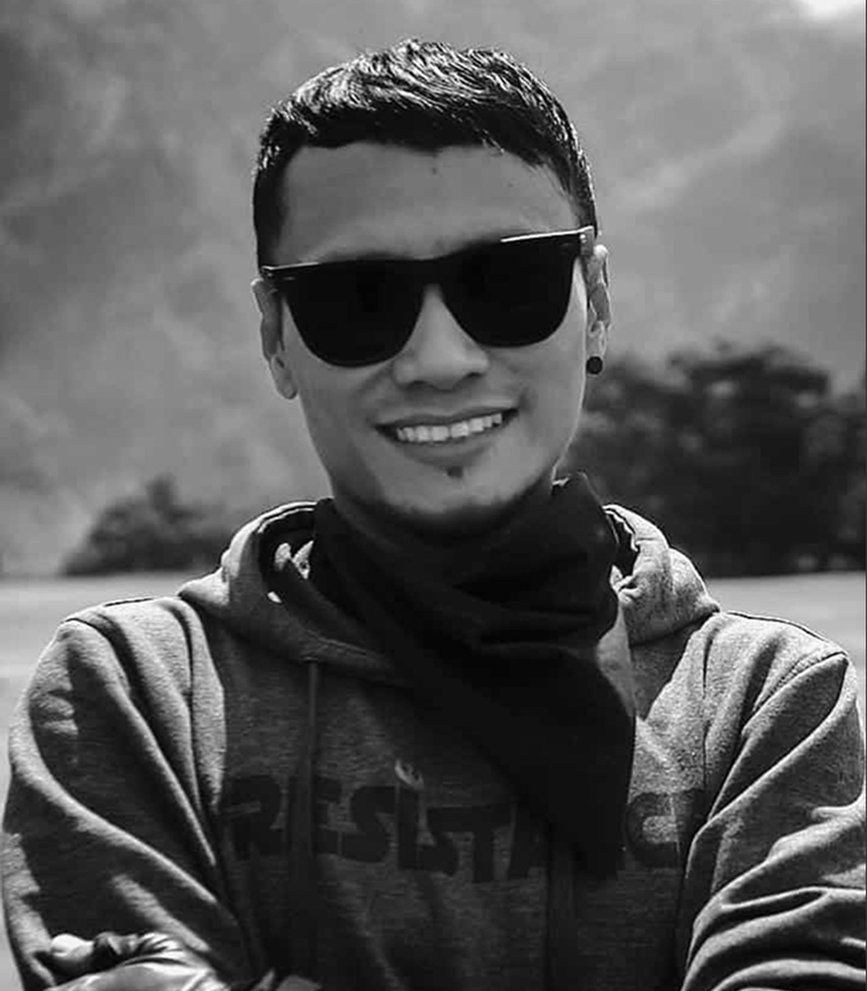 Ata, Pirate Journey co-founder, smiling in sunglasses and a hoodie, black and white portrait