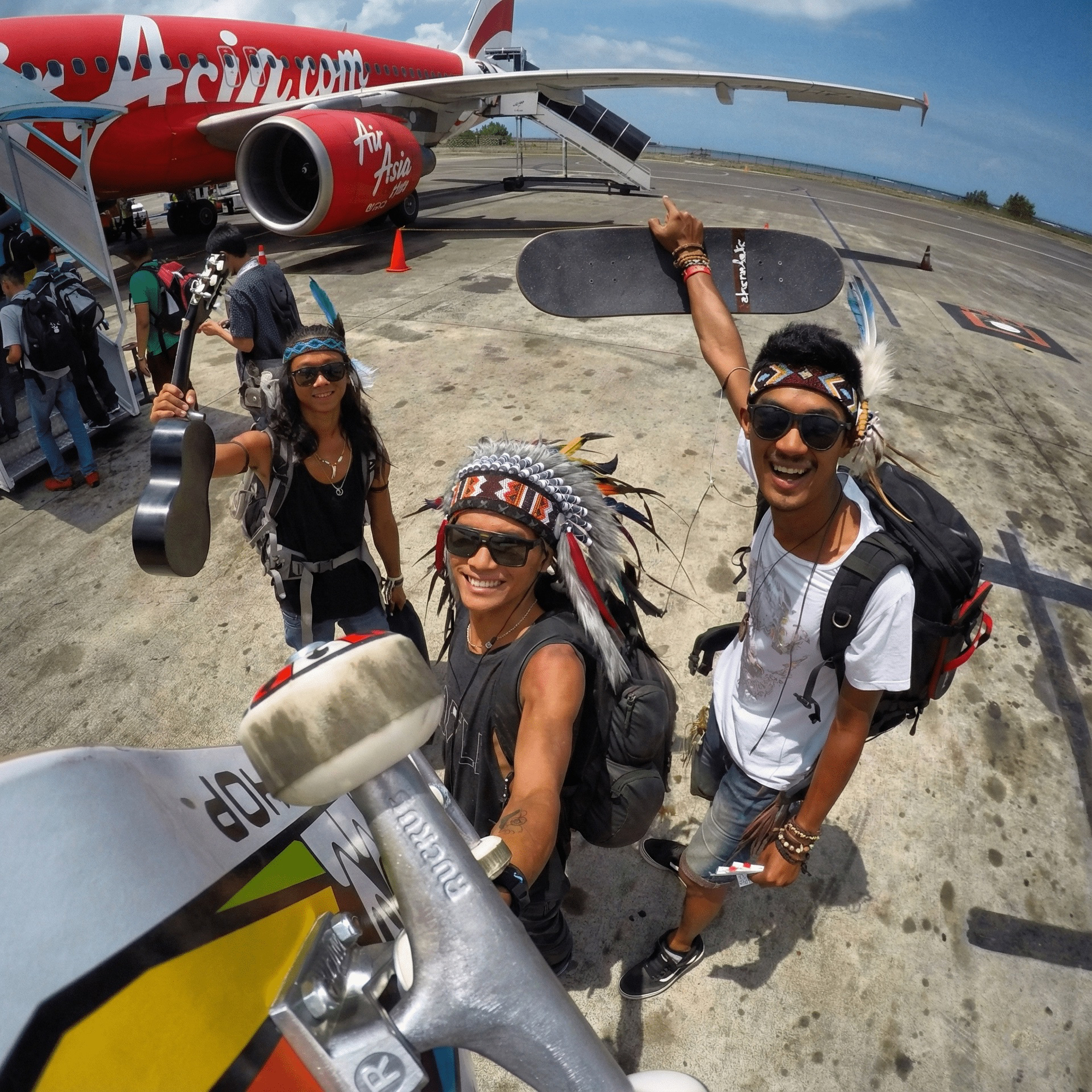 Travellers with skateboards and a guitar boarding a Komodo island tour from Bali