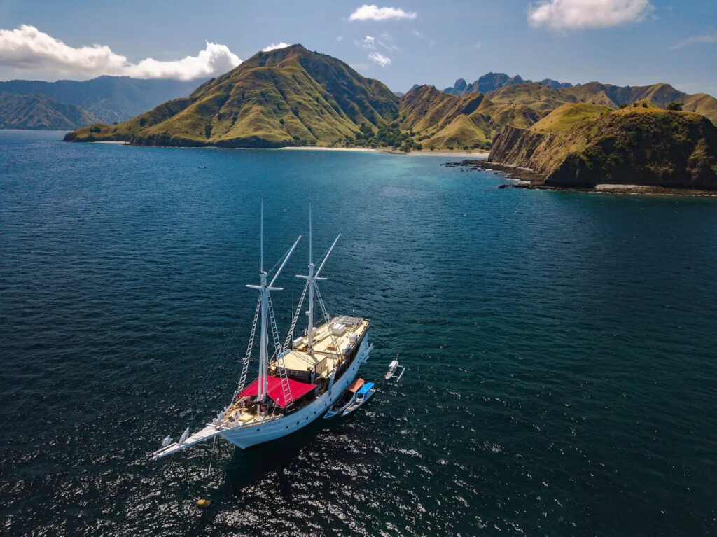 Jakare aerial view anchored in bay surrounded by green hills