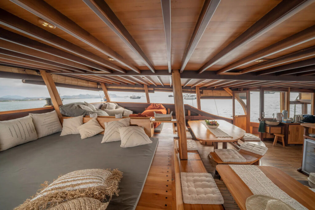 Saloon dining table and cushioned seating with ocean view windows
