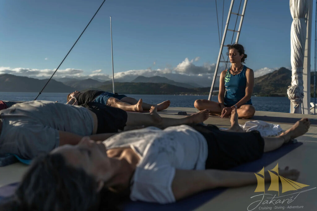 Jakare guests relax in yoga savasana pose on deck