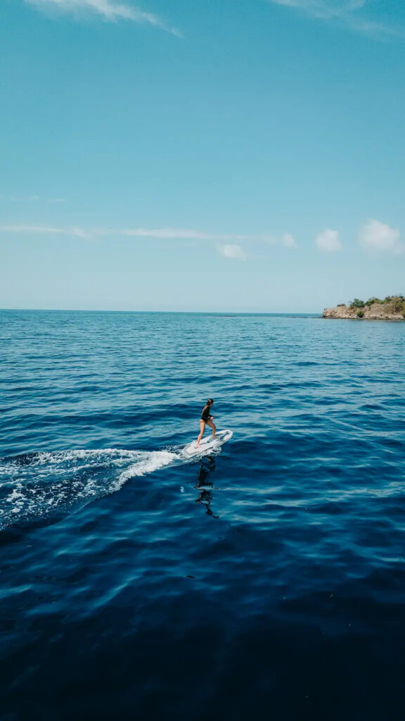 Guest riding an efoil beside the Kayra phinisi