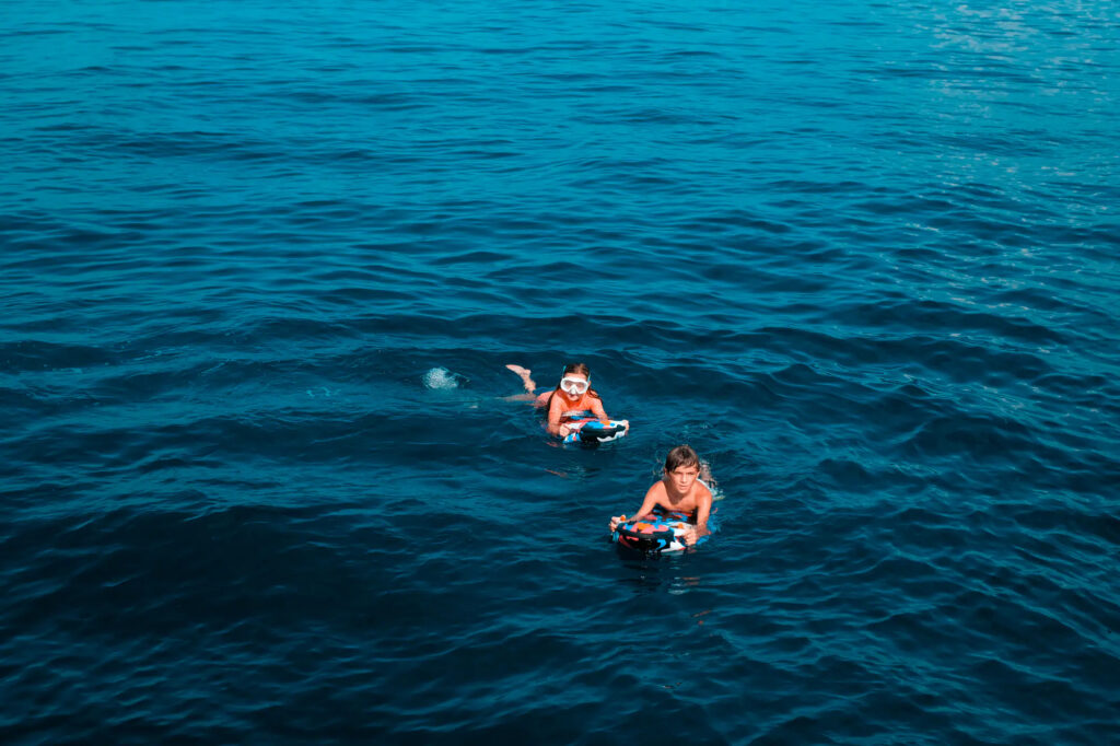 Snorkellers swimming in clear water beside Kayra