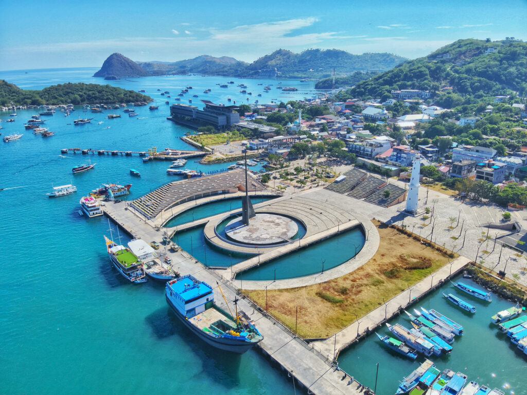 Aerial view of Labuan Bajo harbour, the waterfront esplanade and moored vessels below town