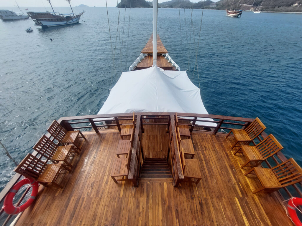 Lady Grace bow deck seating with other phinisi boats anchored in the harbor
