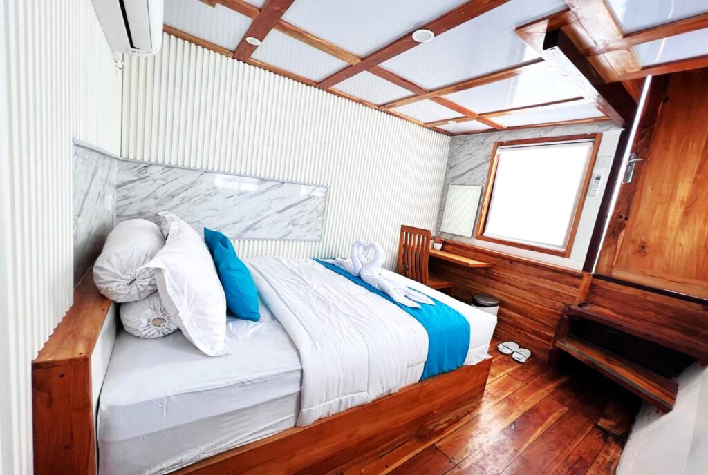Ikan Cabin bed with marble headboard, teal pillow and desk beyond