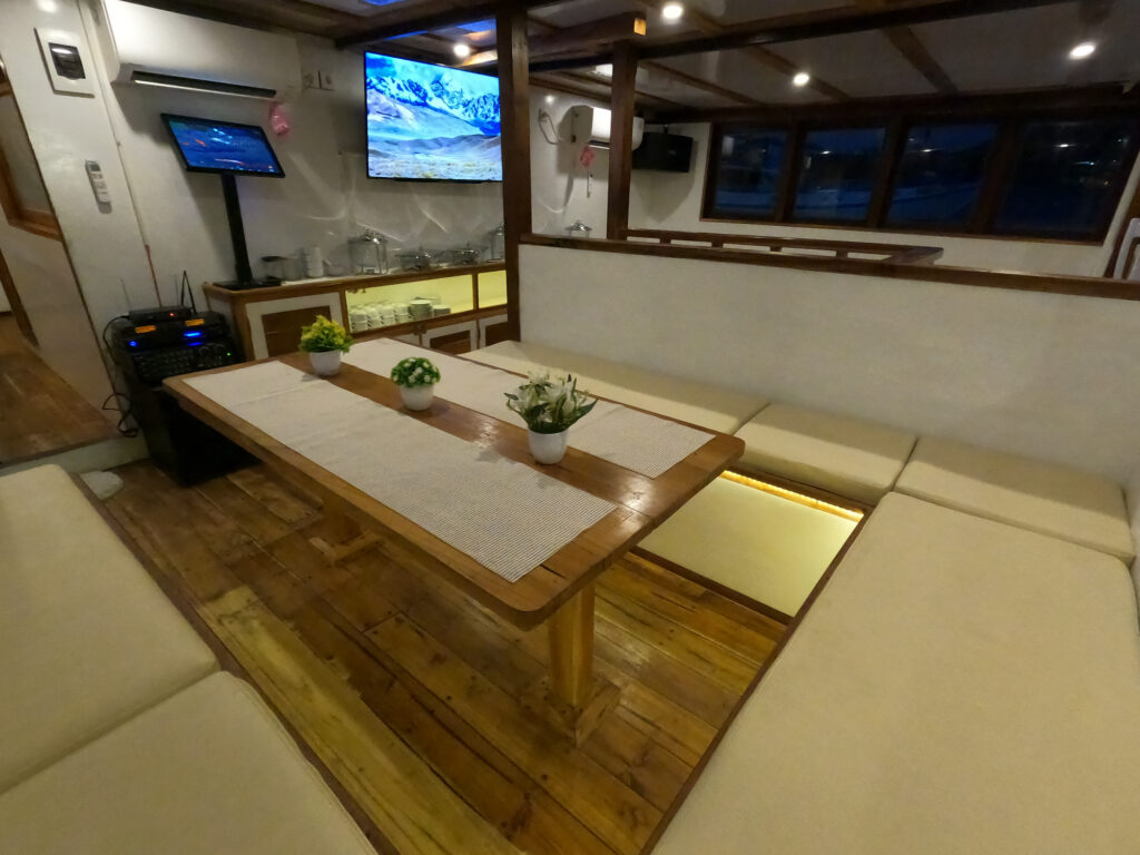Indoor lounge with cream sofas, coffee table and wall-mounted TV screens