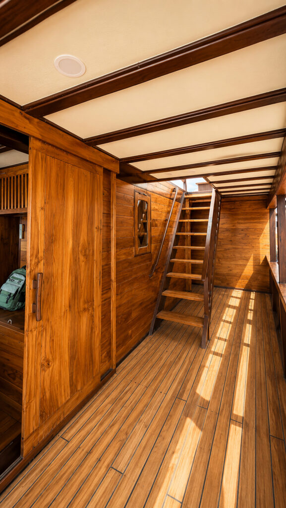 Timber interior passage on Papiton Allo with a ladder stair to the upper deck
