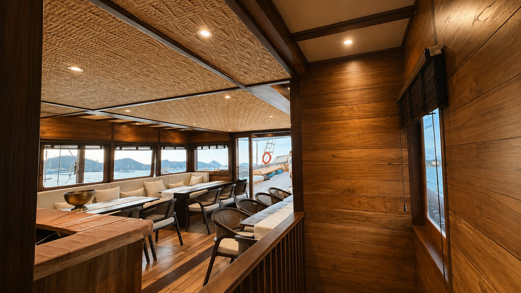 Saloon entry from the side deck with dining tables and woven ceiling panels