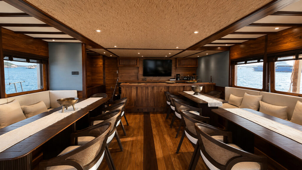 Saloon looking towards the bar and wall screen between two long dining tables