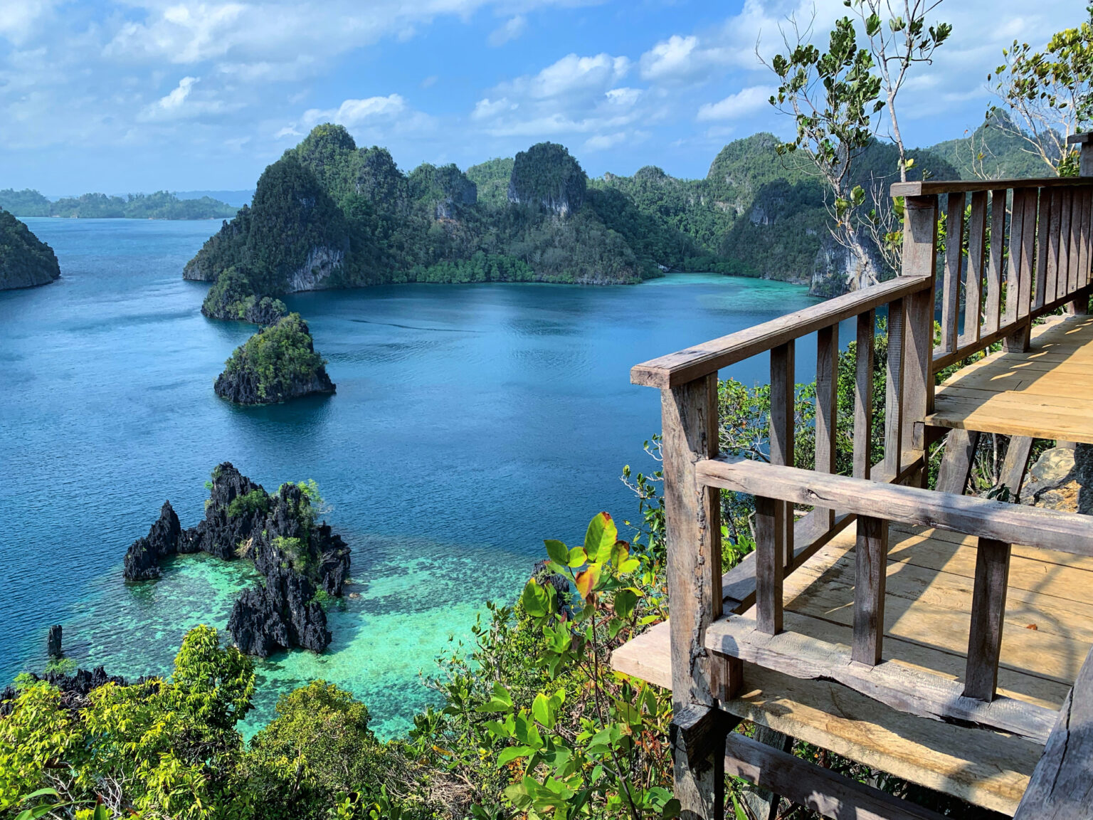 Wooden viewing deck at Piaynemo overlooking karst islets and turquoise shallows, Raja Ampat
